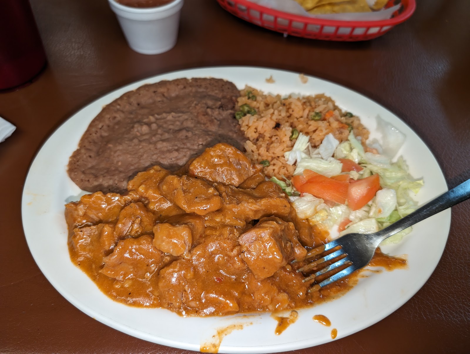 Chile colorado plate with beans, Mexican rice, and fresh salad