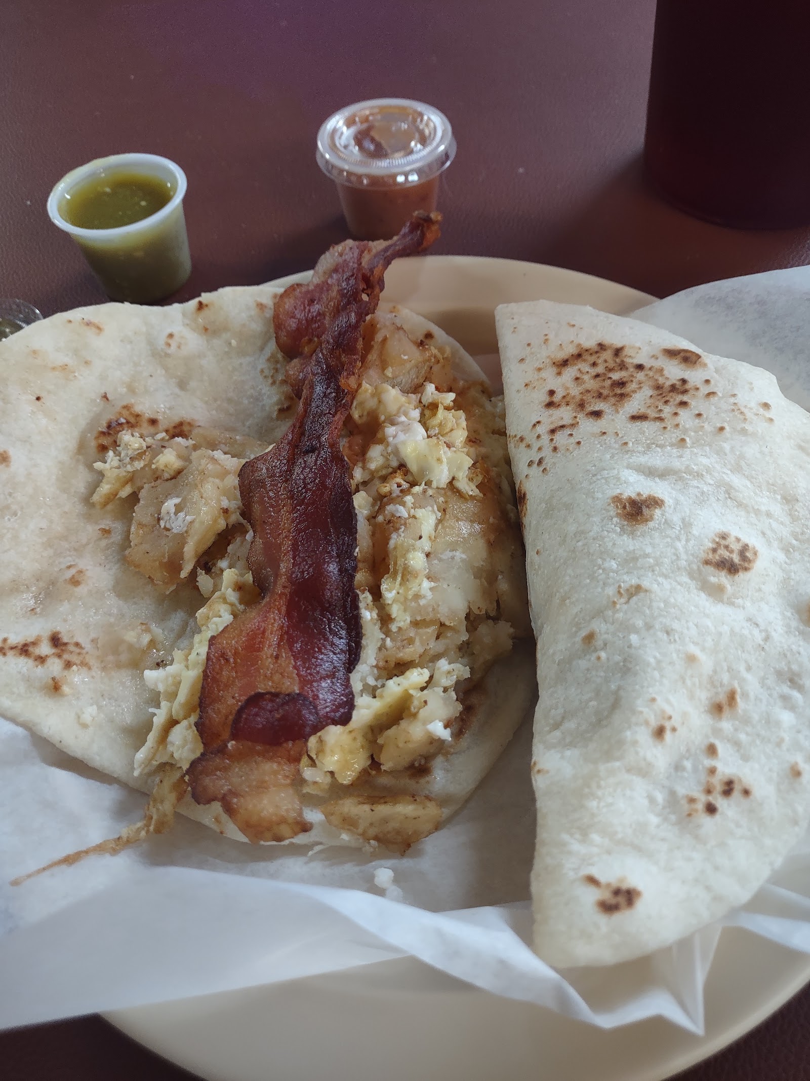 Breakfast taco with bacon, egg, and potato on a handmade flour tortilla